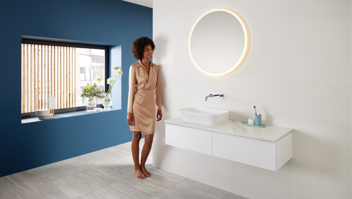 Kobieta stojąca w łazience z produktami z serii Mix & Match firmy Geberit Kobieta stojąca w łazience z produktami z serii Mix & Match firmy Geberit