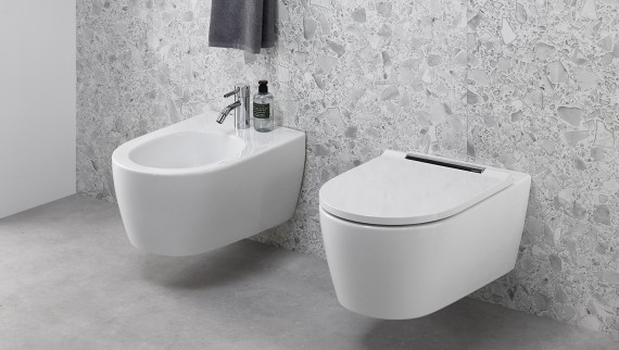 Bidet Geberit ONE i toaleta myjąca AquaClean Sela zamontowane obok siebie w szarej łazience Bidet Geberit ONE i toaleta myjąca AquaClean Sela zamontowane obok siebie w szarej łazience
