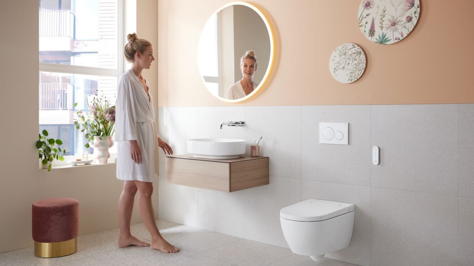 Kobieta w łazience z toaletą myjącą Geberit AquaClean Alba Kobieta w łazience z toaletą myjącą Geberit AquaClean Alba