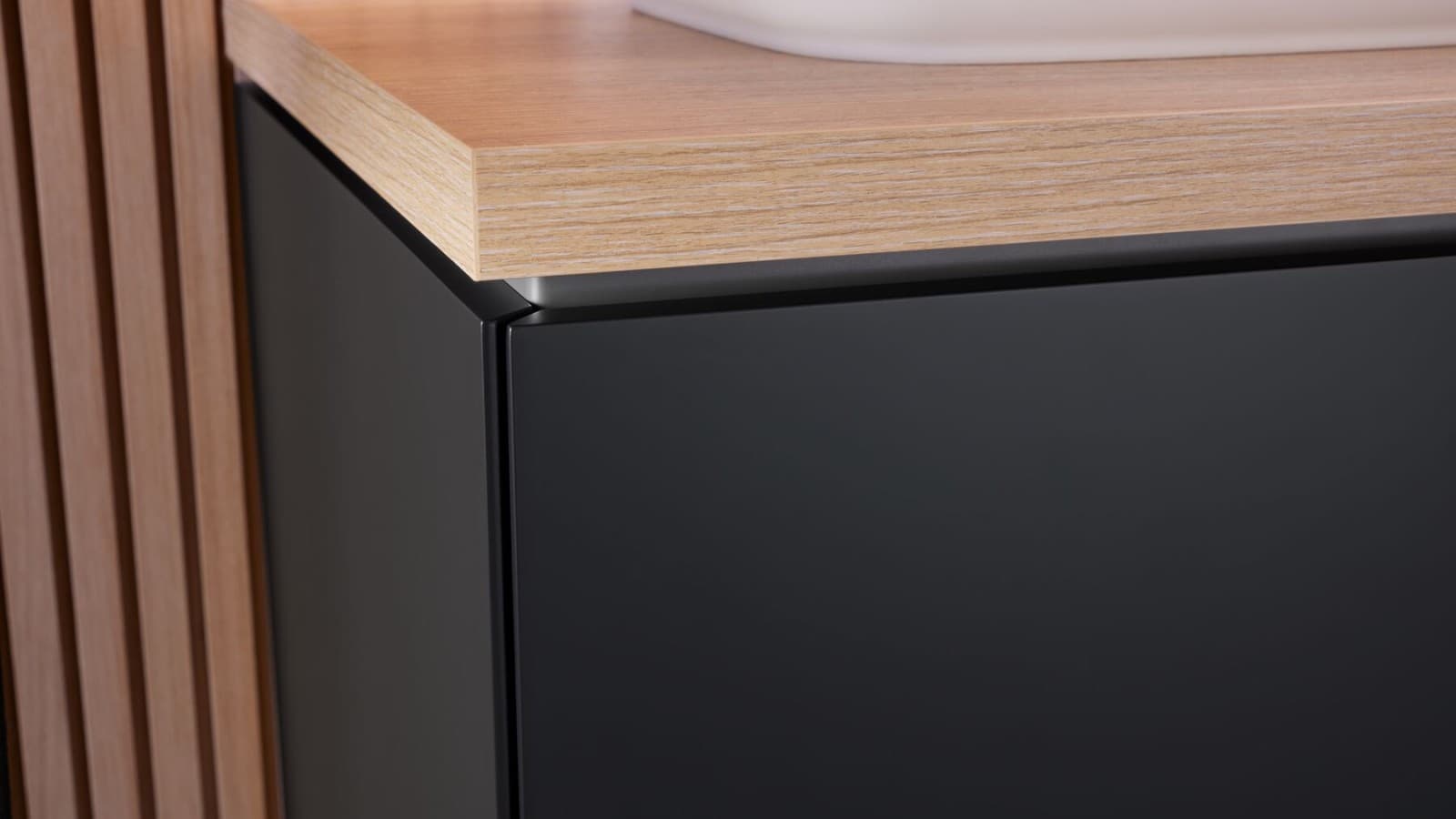Zbliżenie na czarną szafkę łazienkową z drewnianym blatem Zbliżenie na czarną szafkę łazienkową z drewnianym blatem