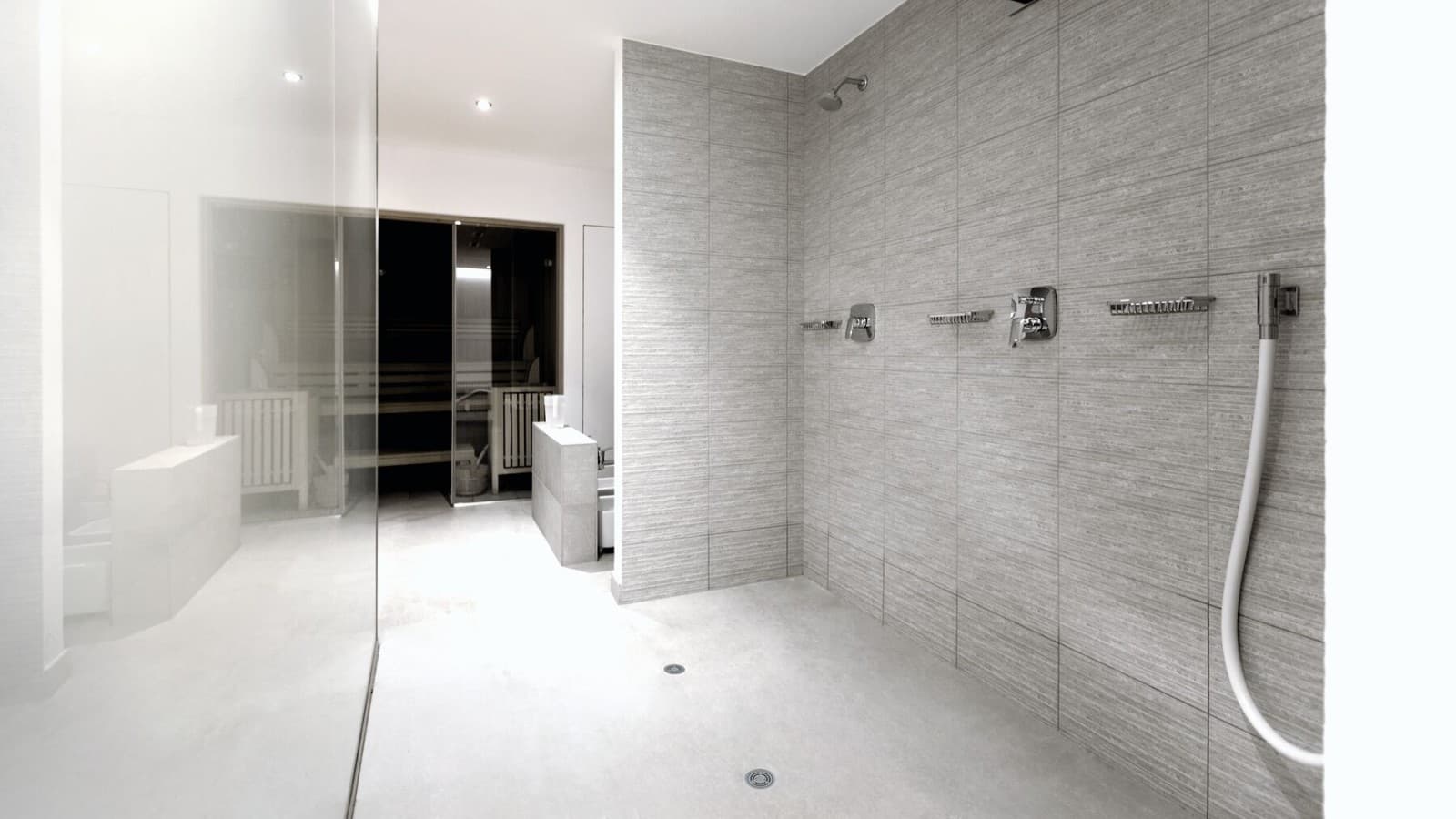 Strefa prysznicowa z odpływami podłogowymi w publicznym obiekcie Strefa prysznicowa z odpływami podłogowymi w publicznym obiekcie