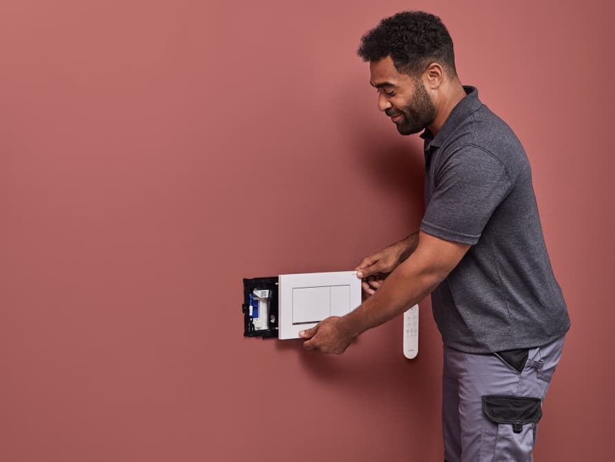 Mężczyzna instaluje urządzenie do usuwania zapachów Geberit DuoFresh Mężczyzna instaluje urządzenie do usuwania zapachów Geberit DuoFresh